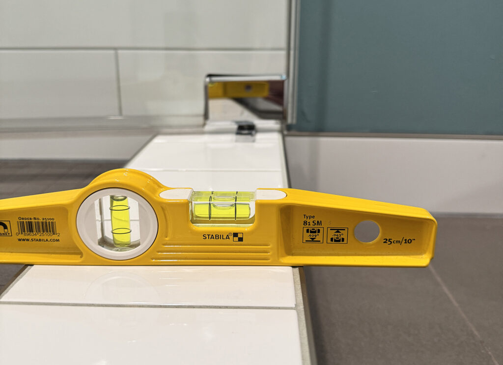 Shower curb installed with no slope causing water to pool