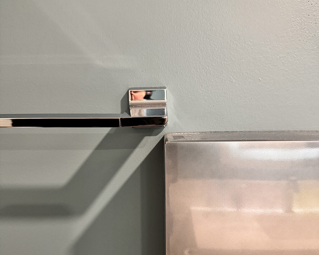 Towel bar overlapping hand dryer